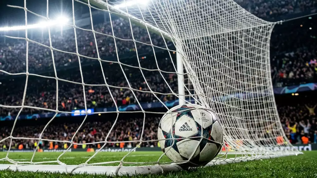 Voetbal in het doelnet onder stadionverlichting, symbool van een doelpuntenrecord