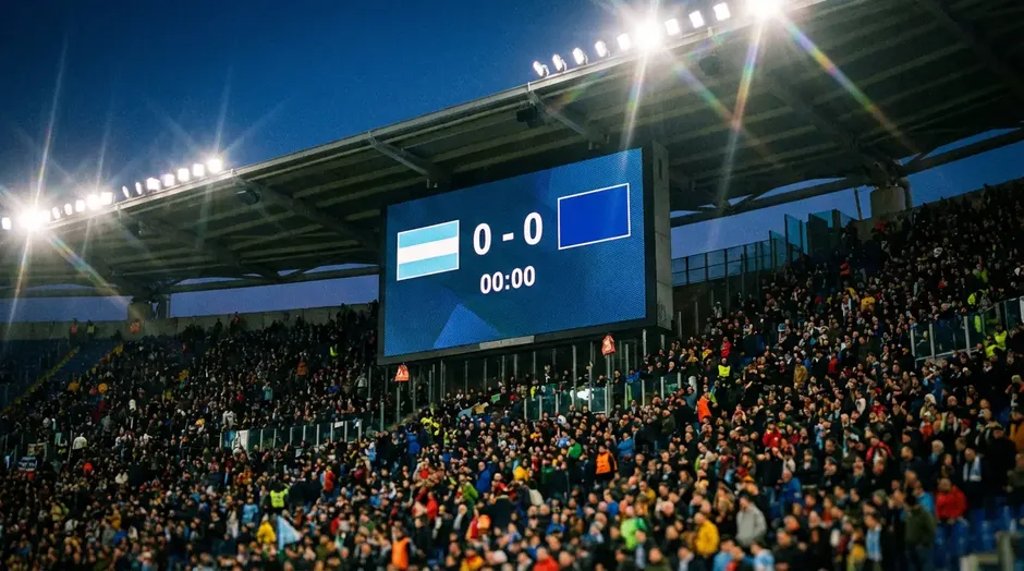 Scorebord in een voetbalstadion met wedstrijdgegevens en teamvlaggen