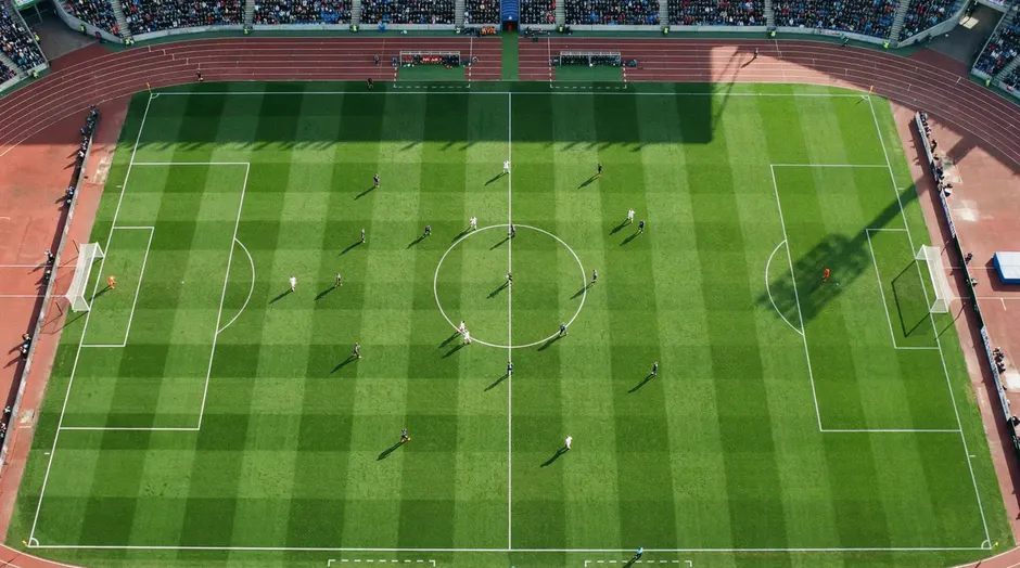 Voetbalveld met tactische lijnen en opstellingsmarkeringen tijdens een groepswedstrijd